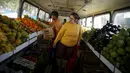 Seorang wanita mencari buah-buahan saat berbelanja di dalam pasar bus 'Sacolao' di Santa Teresa, Rio de Janeiro, Brasil, Selasa (7/7/2015). Pasar bus ini menjual sayur dan buah-buahan dengan harga yang terjangkau. (REUTERS/Pilar Olivares)