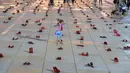 Seorang anak di antara instalasi ratusan sepatu merah untuk memprotes kekerasan terhadap perempuan di kota pesisir Tel Aviv,Selasa (4/12). Sepanjang tahun ini, 24 perempuan Israel tewas akibat tindakan kekerasan dalam rumah tangga. (JACK GUEZ/AFP)