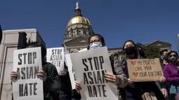 Orang-orang memegang poster saat unjuk rasa "Stop Asian Hate" di luar Gedung Kongres Georgia di Atlanta, Sabtu (20/3/2021). Ratusan demonstran berkumpul mendukung komunitas Asia-Amerika setelah penembakan tempat spa yang menewaskan 8 orang, termasuk di antaranya 6 wanita Asia. (AP Photo/Ben Gray)