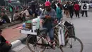 Pedangang membuat minuman untuk massa aksi saat demo penolakan omnibus law di kawasan Patung Kuda, Jakarta, Selasa (20/10/2020). Para pedagang kaki lima memanfaatkan moment aksi massa untuk mencari ke untungan meskipun sangat membahayakan bagi keselamatan mereka. (Liputan6.com/Angga Yuniar)