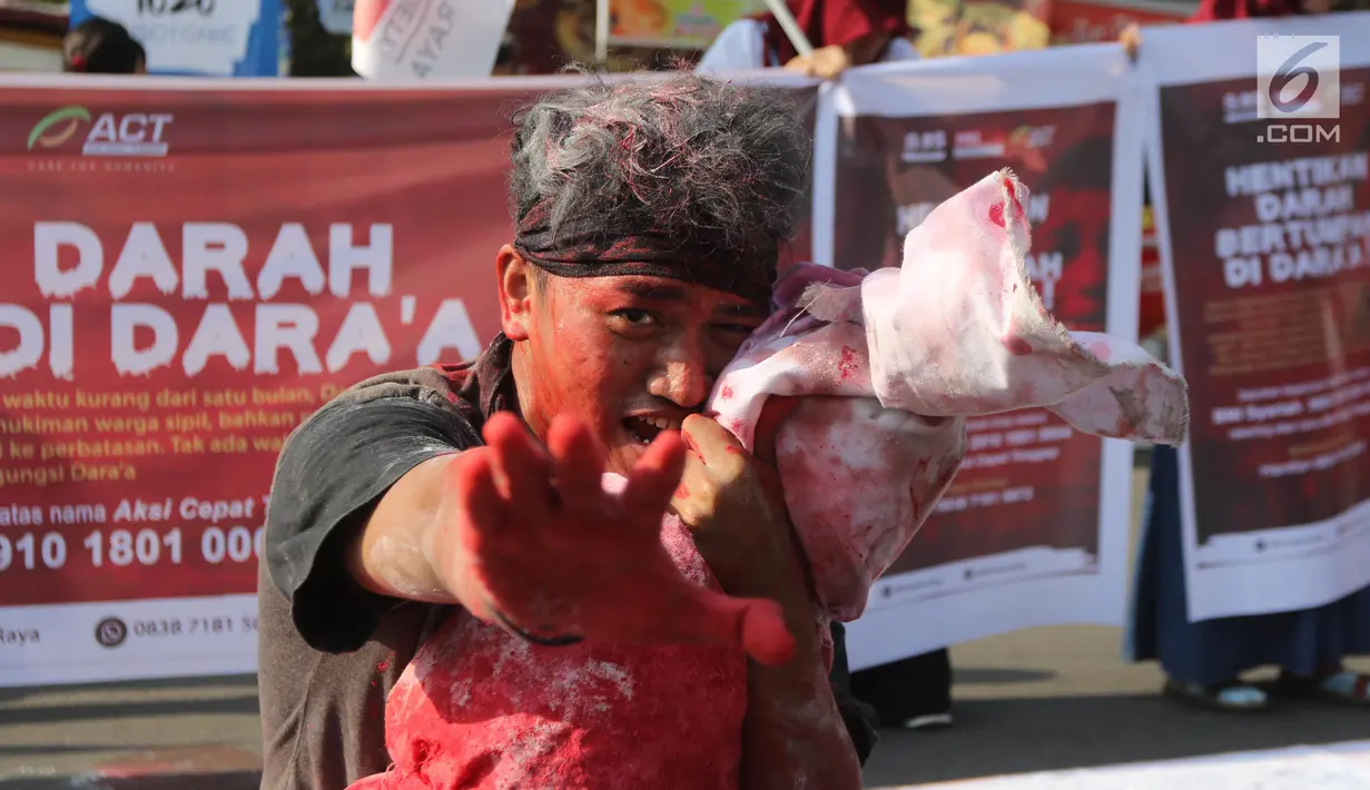 Relawan ACT melakukan teatrikal tentang penderita rakyat Suriah di CFD Bundaran HI, Jakarta, Minggu (15/7). Dalam aksinya relawan juga menggalang dana kemanusiaan untuk para warga sipil Suriah yang menjadi korban peperangan. (Liputan6.com/Arya Manggala)