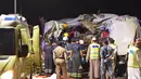 Petugas memeriksa bangkai bus yang kecelakaan akibat menabrak sebuah truk di jalan raya antara Ibri dan Fahud, Oman bagian barat, Selasa (1/3). Sebanyak 18 orang dari beberapa kewarganegaraan tewas dan 14 lainnya luka-luka. (STRINGER/Omani Police/AFP) 