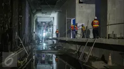 Pekerja melihat lembaran kerja proyek di dalam terowongan MRT yang dalam tahap penyelesaian di Jakarta (6/4). Pengerjaan jalur MRT elevated sepanjang 10 km dari Lebak Bulus hingga Sisingamaraja telah mencapai progres 53,62. (Liputan6.com/Faizal Fanani)