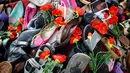 Tumpukan sepatu bertabur bunga mewarnai unjuk rasa menentang pidato Menteri Kehakiman Iran, Sayyid Alireza Avaei di hadapan dewan HAM Perserikatan Bangsa-Bangsa, di luar kantor PBB, Jenewa, Swiss, Selasa (27/2). (Valentin Flauraud/Keystone via AP)
