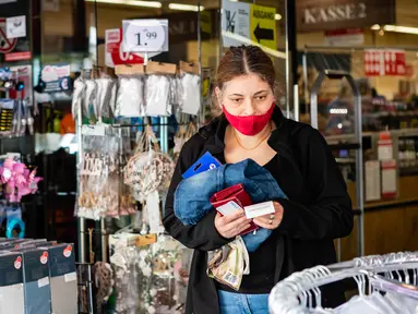 Seorang perempuan bermasker meninggalkan sebuah toko di ibu kota Jerman, 29 April 2020. Berlin mewajibkan penggunaan masker di seluruh gerai usaha pada Rabu (29/4), sementara kewajiban mengenakan masker sudah diberlakukan di seluruh moda transportasi publik sejak Senin (27/4). (Xinhua/Binh Truong)