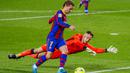 Penyerang Barcelona, Antoine Griezmann, berusaha melewati kiper Real Sociedad, Alex Remiro, pada laga Liga Spanyol di Stadion Camp Nou, Kamis (17/12/2020). Barcelona menang dengan skor 2-1. (AP/Joan Monfort)