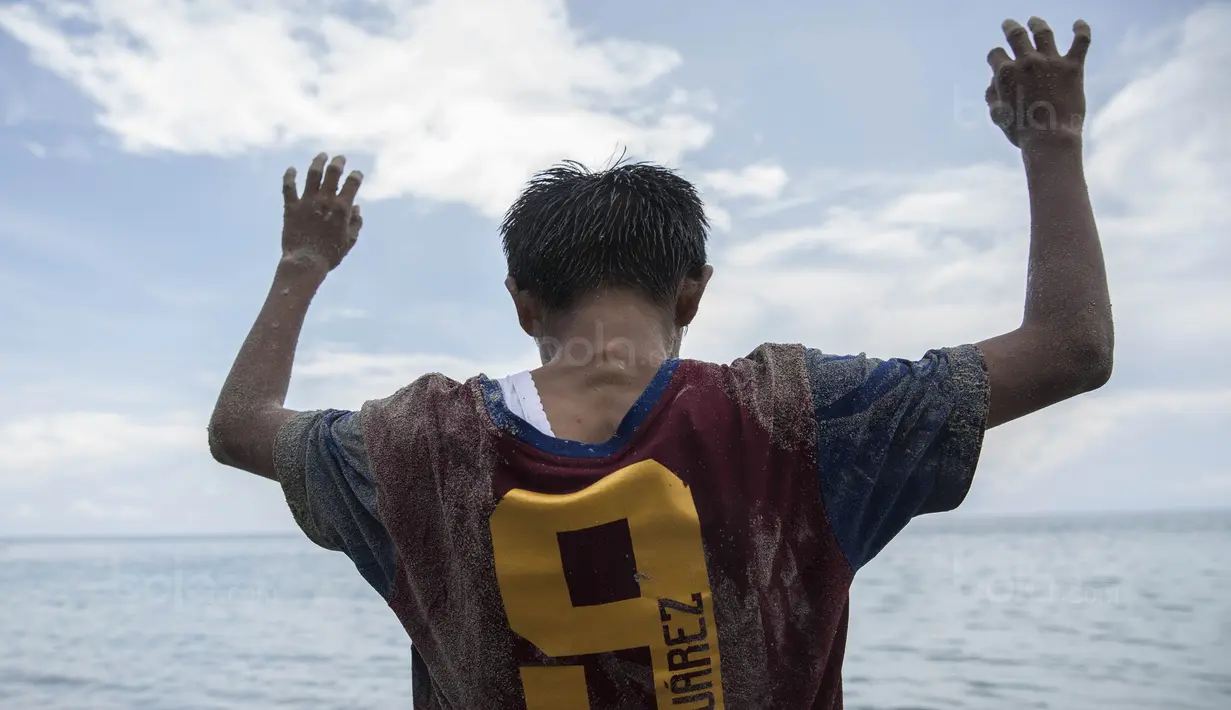 Pesepak bola SSB Tulehu Putra, Rizki Lestaluhu, mengangkat tangan saat  latihan di tepi Pantai Tial, Maluku, Rabu (16/11/2017). Dirinya merupakan salah satu pemain muda berbakat dari Negeri Tulehu. (Bola.com/Vitalis Yogi Trisna)