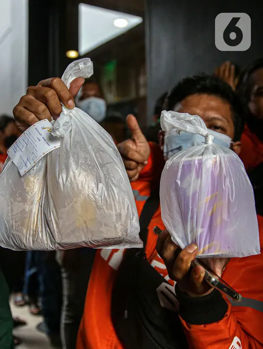 Pengemudi ojek online menunjukkan pesanan saat mengambilnya di gerai cepat saji McDonald's Raden Saleh, Jakarta, Rabu (9/6/2021). Puluhan driver ojek online mengabaikan protokol kesehatan saat mengantre pesanan BTS Meal yang mulai dijual. (Liputan6.com/Faizal Fanani)