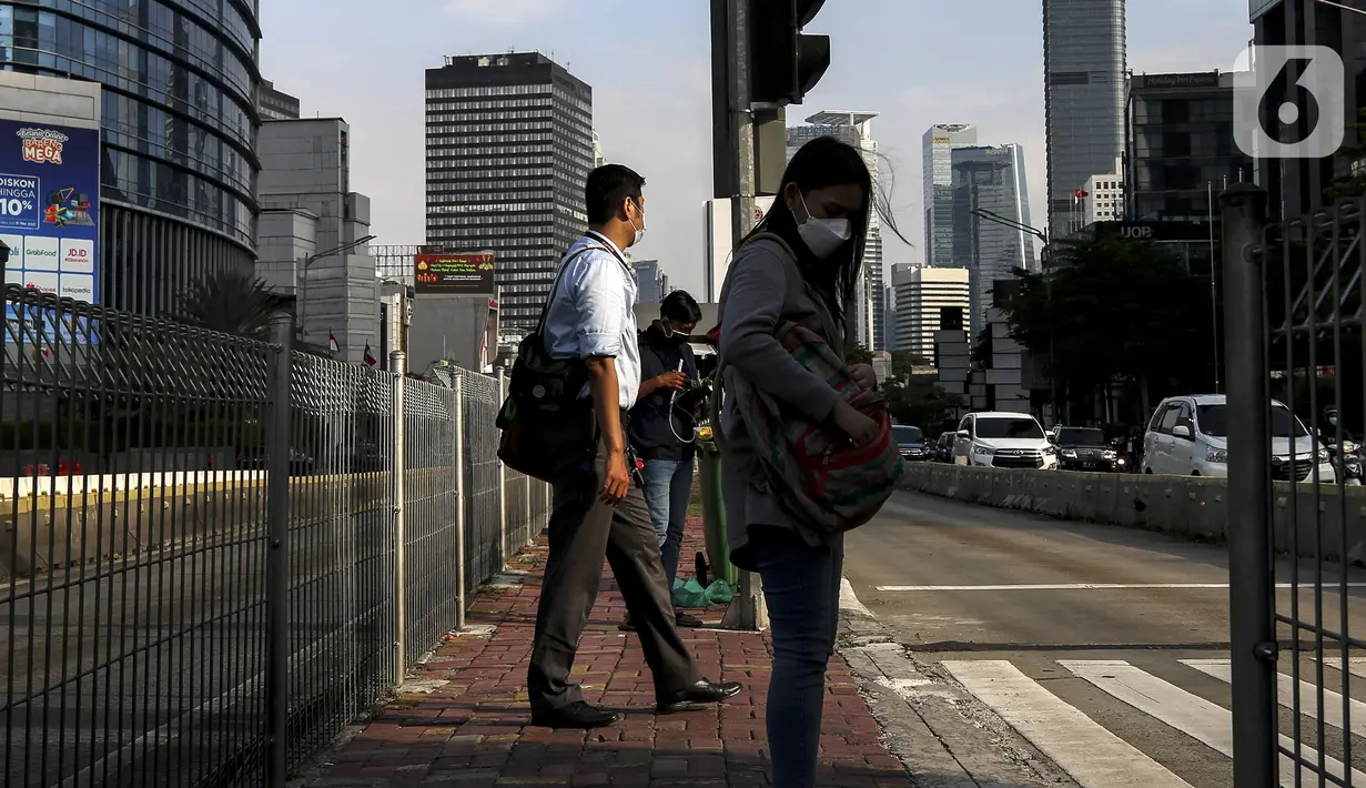Aktivitas pekerja pada saat jam pulang kantor di kawasan Sudirman, Jakarta, Selasa (18/5/2021). Kamar Dagang dan Industri bersama pemerintah telah resmi memulai program Vaksinasi Gotong Royong untuk para pekerja swasta. (Liputan6.com/Johan Tallo)