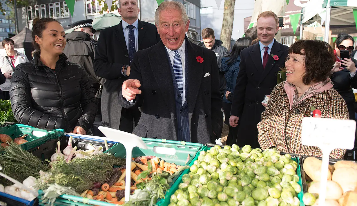 Pangeran Charles berbincang dengan pedagang ketika mengunjungi Swiss Cottage Farmers Market di London utara, Rabu (6/11/2019). Kunjungan Pangeran Charles dan Camila untuk mengucapkan selamat dan memperingati ulang tahun ke-20 pasar tersebut. (Eddie Mulholland / POOL / AFP)