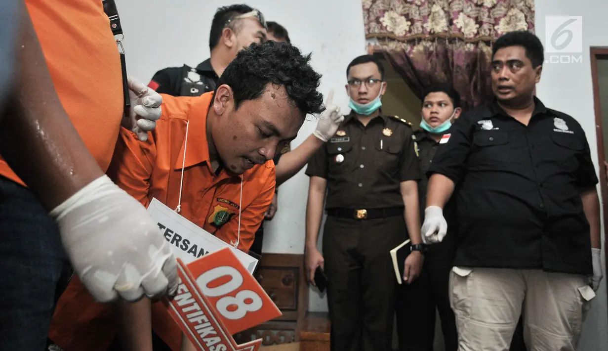 Tersangka Haris Simamora melakukan adegan rekonstruksi pembunuhan keluarga Diperum Nainggolan di Jalan Bojong Nangka, Bekasi, Rabu (21/11). Tersangka pembunuhan satu keluarga di Bekasi itu menjalani 37 adegan rekonstruksi. (Merdeka.com/Iqbal S. Nugroho)