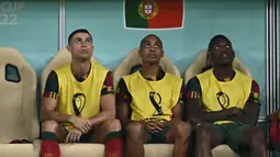 Cristiano Ronaldo (kiri) duduk di bangku cadangan bersama Joao Mario (tengah) dan Rafael Leao (kanan) selama pertandingan sepak bola babak 16 besar Piala Dunia 2022 antara Portugal dan Swiss di Stadion Lusail, Lusail, Qatar, Selasa (6/12/2022). Keputusan mencadangkan Ronaldo diambil oleh sang pelatih, Fernando Santos. (Paul ELLIS / AFP)