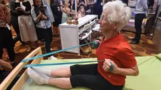 Pesenam tertua di dunia asal Jerman, Johanna Quaas (92) menunjukkan latihan penguatan di tempat tidur khusus untuk orang tua saat Forum Inovasi Aging Asia Internasional ke-8 di Singapura, Selasa (25/4). (AFP PHOTO / ROSLAN RAHMAN)