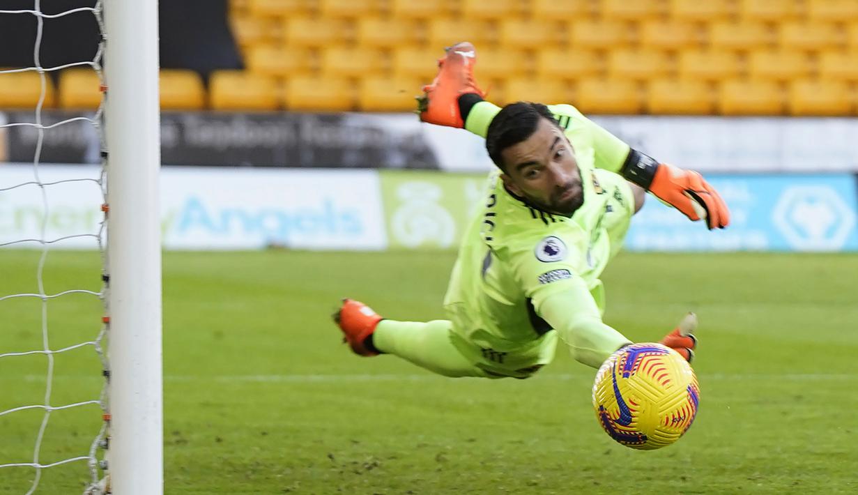 Kiper Wolverhampton Wanderers, Rui Patricio, menghalau bola saat melawan Aston Villa pada laga Liga Inggris di Stadion Molineux, Minggu (13/12/2020). Aston Villa menang dengan skor 0-1. (Tim Keeton/Pool/AFP)
