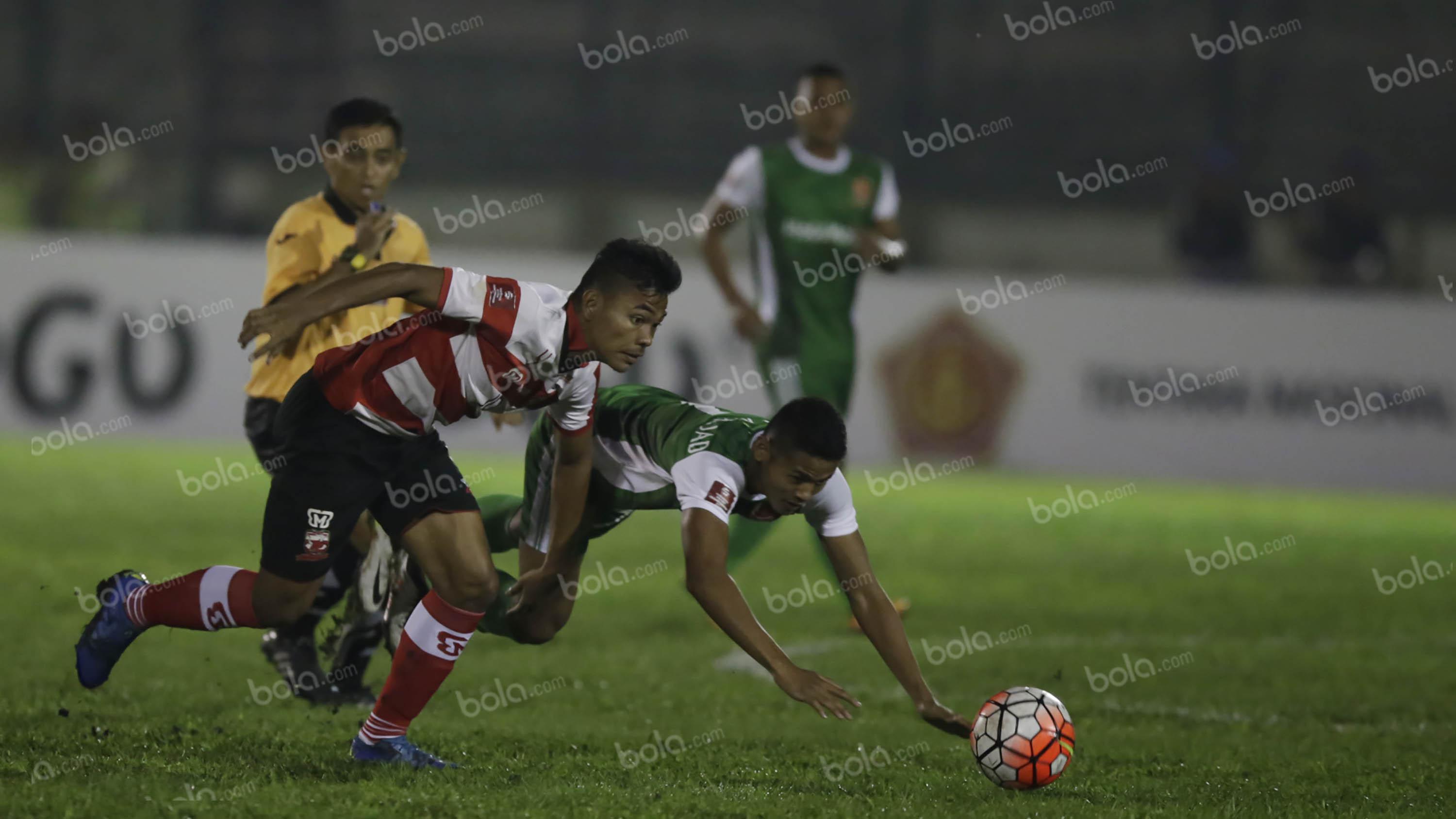 Pemain PS TNI, Dimas Drajad, berebut bola dengan pemain Madura United, Asep Berlian (kiri), dalam laga Torabika Soccer Championship presented by IM3 Ooredoo di Stadion Siliwangi, Bandung, Minggu (1/5/2016). (Bola.com/Vitalis Yogi Trisna)