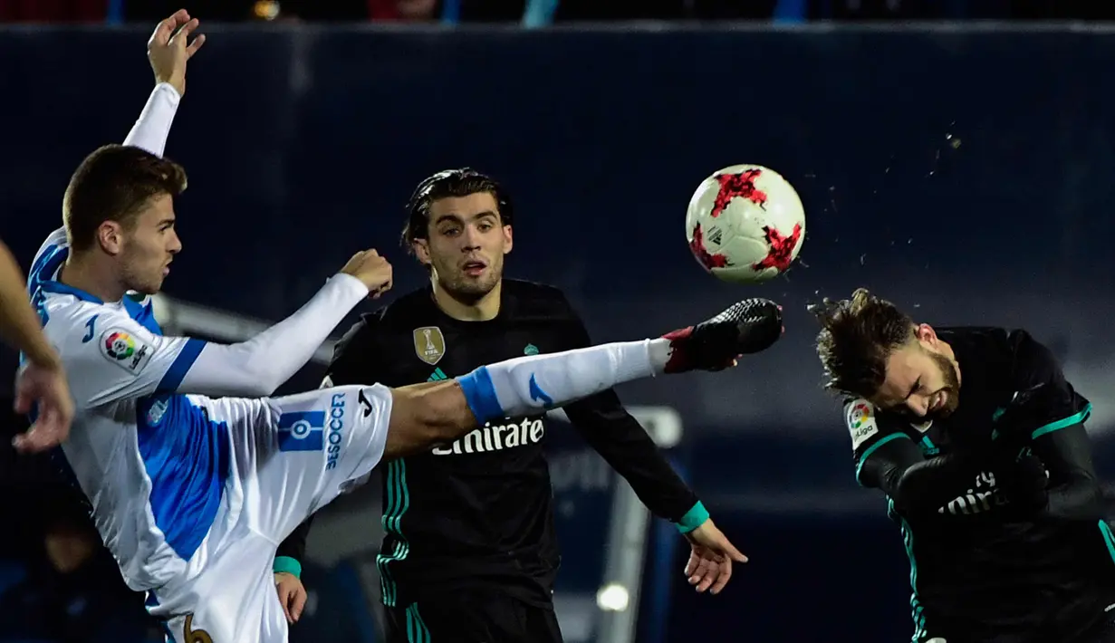 Penyerang Real Madrid, Borja Mayoral (kanan) berebut bola dengan gelandang Leganes, Gerard Gumbau saat bertanding di perempat final Copa del Rey di Estadio Municipal de Butarque (18/1). Madrid menang tipis 1-0 atas Leganes. (AFP Photo/Oscar Del Pozo)