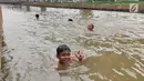 Anak-anak berenang di Sungai Kalimalang, Jakarta Timur, Jumat (5/7/2019). Tingginya suhu udara Ibu Kota akibat musim kemarau menyebabkan anak-anak tersebut berenang di Sungai Kalimalang meski dengan kondisi seadanya. (Liputan6.com/Immanuel Antonius)