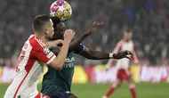 Bek Bayern Munchen Raphael Guerreiro berebut bola dengan penyerang Arsenal Bukayo Saka pada duel leg kedua perempat final Liga Champions 2023/2024 di Allianz Arena pada Kamis (18/4/2024) dinihari WIB. (AP Photo/Matthias Schrader)