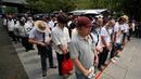 Orang-orang berhenti sejenak untuk mengheningkan cipta saat mereka mengantre untuk memberikan penghormatan ketika berkunjung ke Kuil Yasukuni di Tokyo, Jepang, Selasa (15/8/2023). Aksi tersebut untuk memperingati 78 tahun penyerahan Jepang kepada Sekutu dalam Perang Dunia II tahun 1945. (Kazuhiro NOGI/AFP)