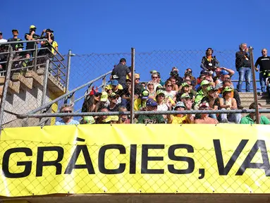 Para penggemar Valentino Rossi memberi dukungan untuk The Doctor jelang babak kualifikasi MotoGP Valencia 2021, Sabtu (13/11/2021). (AFP/Jose Jordan)