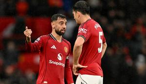Gelandang Manchester United asal Portugal #08, Bruno Fernandes, berbicara dengan bek Manchester United asal Inggris #05, Harry Maguire (kanan), dalam pertandingan&nbsp;Premier League antara Manchester United dan Chelsea di Old Trafford, Manchester, Inggris barat laut, pada 20 September 2025. (Oli SCARFF/AFP)