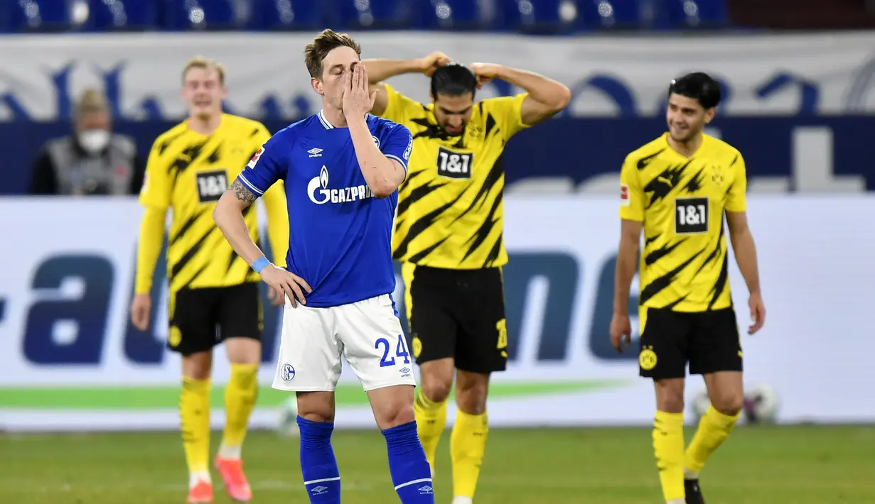 Bek Schalke, Bastian Oczipka (depan) tampak kecewa usai timnya kebobolan gol kedua saat menghadapi Borussia Dortmund dalam laga lanjutan Liga Jerman 2020/21 pekan ke-22 di Veltins Arena, Sabtu (20/2/2021). Schalke kalah 0-4 dari Borussia Dortmund. (AP/Martin Meissner/Pool)