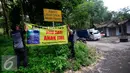 Warga memasang spaduk di jalan desa Glagahsari, Cangkringan Sleman yang di tanami sejumlah pohon, (23/2). Aksi penanaman pohon sebagai bentuk protes atas rusaknya jalan yang belum diperbaiki sejak 5 tahun letusan Merapi. (Liputan6.com/Boy Harjanto)