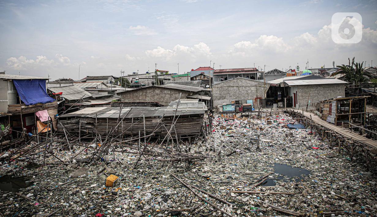 Suasana jembatan kayu di antara sampah di perkampungan nelayan Cilincing, Jakarta, Minggu (21/2/2022). Peringatan HPSN 2022, Pemprov DKI Jakarta mengajak warga Jakarta untuk peduli sampah mulai dari lingkungan terdekat minimal dengan cara memilah sampah dari rumah. (Liputan6.com/Faizal Fanani)