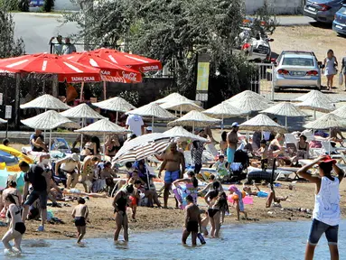 Warga berlibur di sebuah pantai di Distrik Ayvalik, Provinsi Balikesir, Turki, 4 Agustus 2020. Ramainya kunjungan warga Turki ke pantai-pantai selama liburan empat hari Idul Adha pekan lalu memicu kekhawatiran merebaknya kembali pandemi COVID-19 di negara itu. (Xinhua/Osman Orsal)