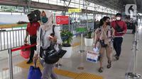 Sejumlah calon penumpang berjalan untuk memasuki rangkaian kereta api Airlangga di Stasiun Pasar Senen, Jakarta, Minggu (10/4/2022). PT KAI Daop 1 telah membuka pelayanan kereta api jarak jauh sebanyak 22 perjalanan dengan kapasitas penumpang 100 persen. (Liputan6.com/Herman Zakharia)