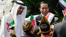 Presiden Jokowi bersama Putra Mahkota Abu Dhabi, Sheikh Mohamed Bin Zayed Al Nahyan menyapa sejumlah anak berpakaian daerah saat kunjungan kenegaraan di Istana Bogor, Kamis (24/7/2019). Keduanya menggelar pertemuan bilateral guna membahas sejumlah kerja sama. (Willy Kurniawan/Pool Photo via AP)