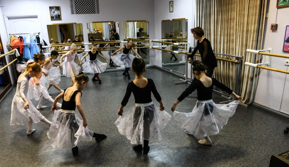 Gadis-gadis kecil mengikuti kelas balet di sebuah studio di Moskow , 22 November 2018. Orang tua dan kakek-nenek duduk di koridor sebuah studio kecil di Moskow utara menunggu anak-anak usia tiga tahun menyelesaikan kelas balet mereka. (Mladen ANTONOV/AFP)