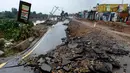 Seorang pria melintas dekat jalan yang rusak akibat gempa bumi yang melanda Jatla di dekat Mirpur, Rabu (25/9/2019).  Jalan-jalan yang rusak serta listrik yang padam menghambat upaya-upaya penyelamatan korban gempa bermagnitudo 5,8 tersebut. (AP Photo/Anjum Naveed)