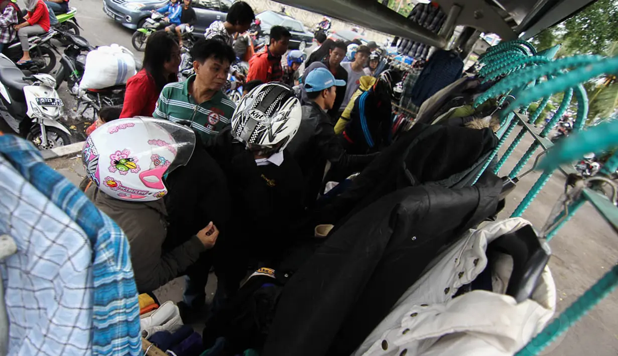 Sejumlah pakaian-pakaian yang dijual terlihat digantung di pagar besi, Minggu (27/4/14). (Liputan6.com/Faizal Fanani)  