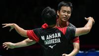 Ganda putra Indonesia Hendra Setiawan (kanan) dan Mohammad Ahsan merayakan kemenangan atas ganda putra Jepang Takuro Hoki dan Yugo Kobayashi pada babak final Kejuaraan Dunia Bulu Tangkis 2019 di Swiss, Minggu (25/8/2019). Ahsan/Hendra menang dengan skor 25-23, 9-21, 21-15. (FABRICE COFFRINI/AFP)