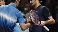 Roger Federer (kanan) menyalami Novak Djokovic seusai mengalahkan petenis nomor satu dunia tersebut  dalam turnamen ATP World Tour Finals 2015 di O2 Arena, London, Rabu (18/11/2015) dini hari WIB. (Reuters/Toby Melville)