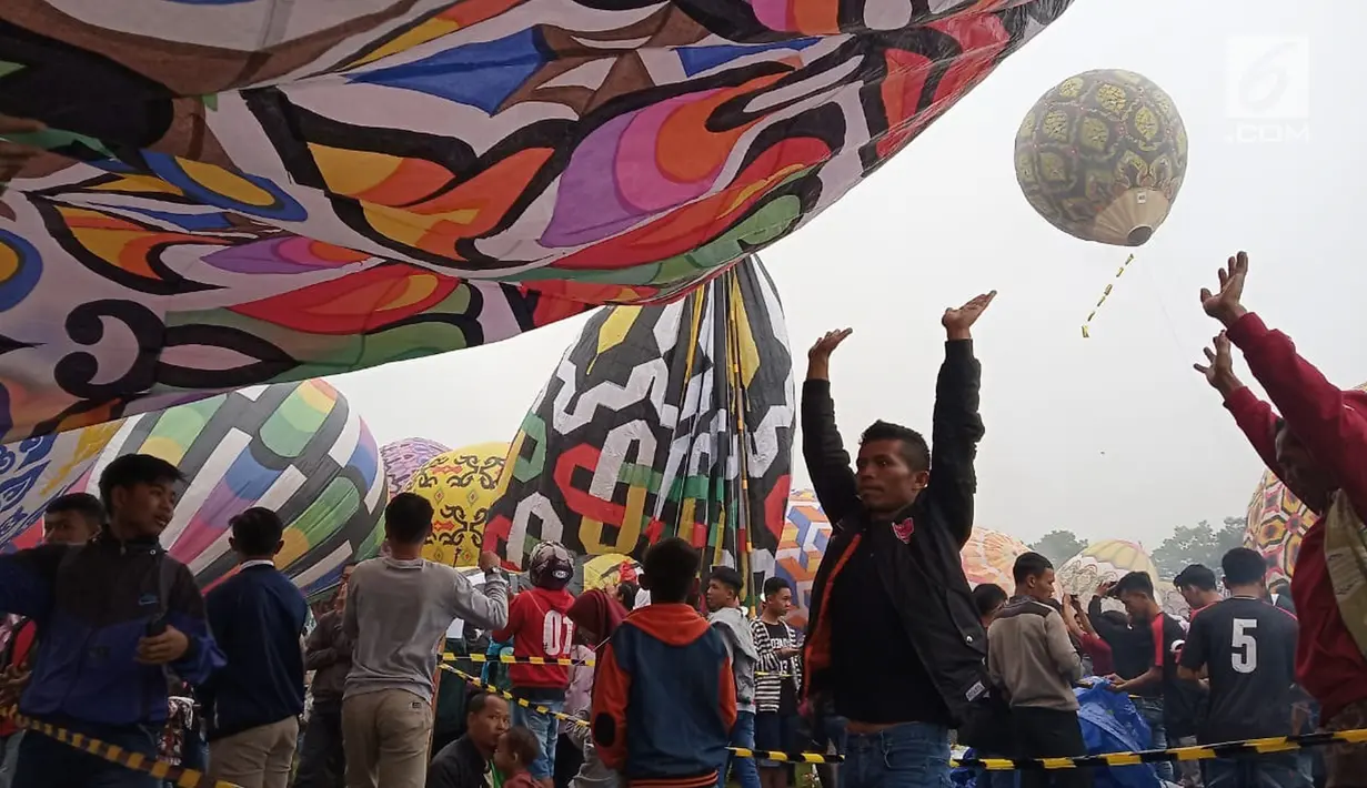 Peserta bersiap menaikan balon udara di Lapangan Pagerejo, Kertek, Kabupaten Wonosobo,  Sabtu (15/6/2019). Festival ini untuk memeriahkan syawalan dan wujud syukur warga yang hidup di lereng gunung sindoro dan sumbing. (Liputan6.com/Gholib)