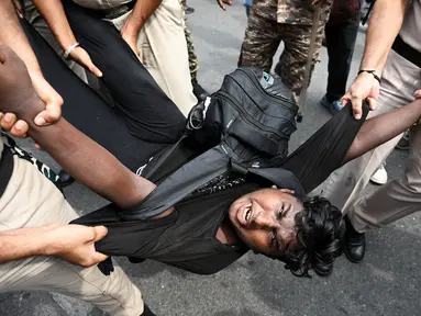 Petugas keamanan menahan seorang demonstran saat aksi unjuk rasa kaum muda yang menuntut pengunduran diri Ketua Komisi Pemilihan Umum India, Gyanesh Kumar, di New Delhi, India, Minggu (11/10/2026). (AP Photo/Vipin)