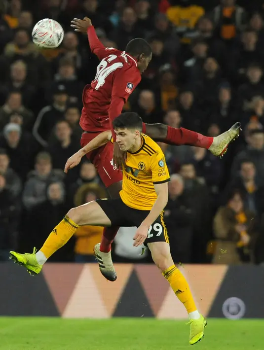 Pemain Wolverhampton Wanderers, Ruben Vinagre berebut bola dengan pemain Liverpool, Rafael Camacho pada laga putaran ketiga Piala FA di Molineux Stadium, Senin (7/1). Liverpool tersingkir dari Piala FA setelah takluk 1-2 dari Wolverhampton (AP/Rui Vieira)