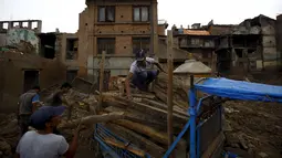 Sejumlah Warga mengumpulkan puing-puing bangunan yang rusak akibat gempa di Bhaktapur, Nepal (14/7/2015). PBB melaporkan dua bulan setelah gempa di Nepal, warga masih sulit mendapatkan makanan dan perawatan kesehatan. (REUTERS/Navesh Chitrakar)