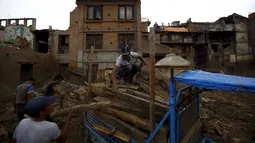 Sejumlah Warga mengumpulkan puing-puing bangunan yang rusak akibat gempa di Bhaktapur, Nepal (14/7/2015). PBB melaporkan dua bulan setelah gempa di Nepal, warga masih sulit mendapatkan makanan dan perawatan kesehatan. (REUTERS/Navesh Chitrakar)