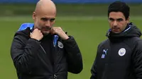 Manajer Manchester City, Pep Guardiola, dan sang asisten pelatih Mikel Arteta. (AFP/Lindsey Parnaby)