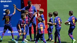 Penyerang baru Barcelona, Ousmane Dembele menyapa anak-anak saat perkenalan dirinya di Stadion Camp Nou, Barcelona, Spanyol, (28/8). Pemain asal Prancis ini dikontrak Barcelona sekitar 147 juta euro. (AP Photo / Manu Fernandez)