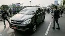 Mobil pelat nomor merah dilempari oleh massa aksi saat melintasi jalan tol seberang Gedung DPR/ MPR RI, Jakarta, Selasa (24/9/2019). Selain menutup ruas tol, kendaraan dinas pemerintah dan milik polisi jadi korban pelemparan dan perusakan oleh mahasiswa. (Liputan6.com/Faizal Fanani)