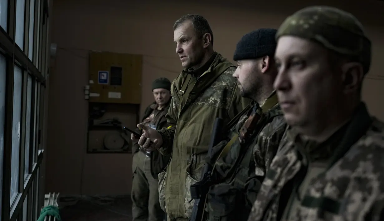 Aktivis Ukraina dan veteran perang di timur negara itu, Ihor Mazur, wakil ketua kelompok nasionalis UNA-UNSO, memegang telepon genggam di dalam gedung bioskop di Kyiv, Ukraina, Senin (7/3/2022). (AP Photo/Vadim Ghirda)