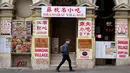 Seorang pria berjalan melewati sebuah restoran tertutup di jalan yang sepi di Chinatown Melbourne, ketika kota itu bersiap untuk mencabut beberapa pembatasan, Selasa (19/10/2021). Melbourne menjalani lockdown terpanjang di dunia, melebihi penguncian di Buenos Aires selama 234 hari (William WEST/AFP)