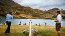 Orang-orang memainkan permainan tradisional 'Gilihuesine' di resor pegunungan Bettmeralp, Swiss (16/9). Permainan ini dimainkan dengan cara memukul tulang kaki sapi dengan tongkat. (Valentin Flauraud/Keystone via AP)