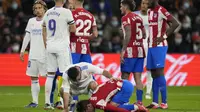 Pemain Atletico Madrid Antoine Griezmann, terbawah, terbaring kesakitan di lapangan, setelah menantang pemain Real Madrid Dani Carvajal, kiri bawah, selama pertandingan sepak bola La Liga Spanyol antara Real Madrid dan Atletico Madrid di stadion Santiago