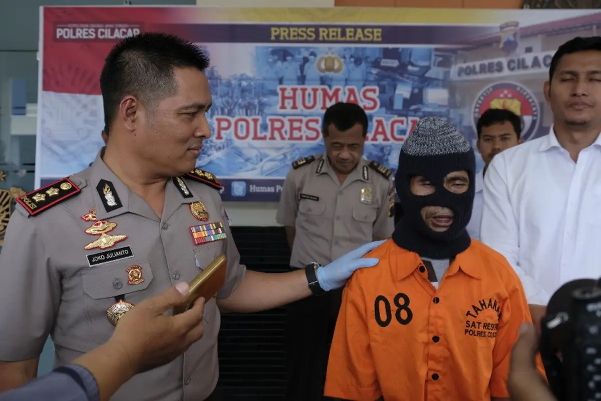 Kapolres Cilacap, AKBP Djoko Julianto menanyai tersangka guru cabul, Nasro. (Foto: Liputan6.com/Polres Cilacap/Muhamad Ridlo)