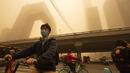 Orang-orang mengendarai sepeda melintasi persimpangan di tengah badai pasir pada jam sibuk pagi hari di kawasan pusat bisnis di Beijing, China, Senin (15/3/2021). Kota Beijing diselimuti debu cokelat tebal, Senin pagi, yang dibawa angin kencang dari Mongolia. (AP Photo/Mark Schiefelbein)